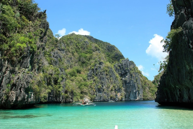 Outrigger boat on the turquoise water of Big Lagoon, El Nido