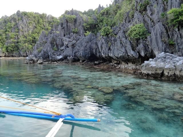 Jagged limestone shoreline over a shallow reef in El Nido, Palawan