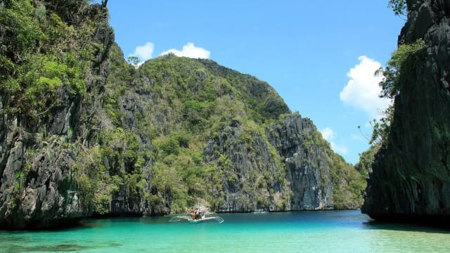 Outrigger boat on the turquoise water of Big Lagoon, El Nido