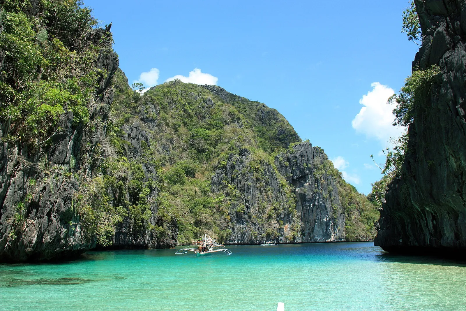 Outrigger boat on the turquoise water of Big Lagoon, El Nido